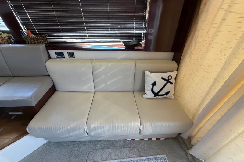 Slide: The Image of Interior of 2010 Sea Ray 390 Sedan Bridge with beige seating and anchor-themed pillow. - 53