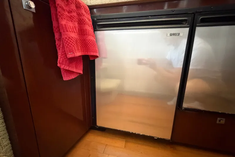 Slide: The Image of Interior of 2010 Sea Ray 390 Sedan Bridge with stainless steel fridge and red towel. - 69