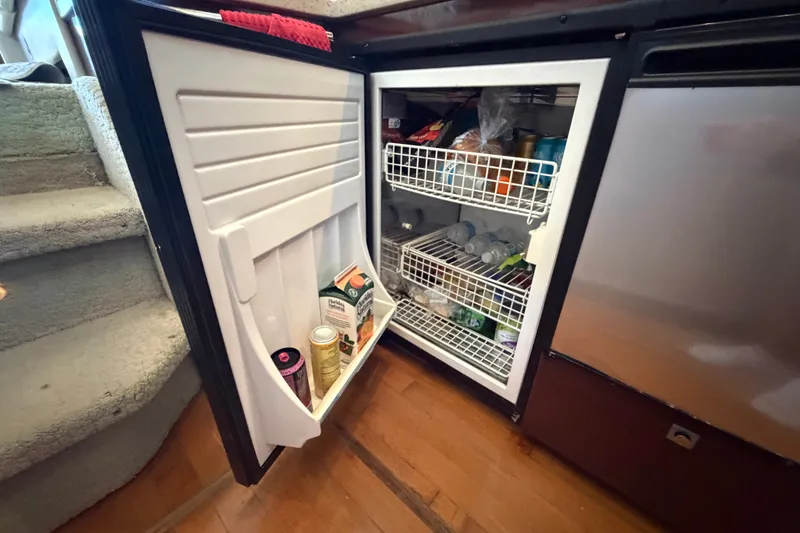 Slide: The Image of Open refrigerator on 2010 Sea Ray 390 Sedan Bridge, stocked with beverages and groceries. - 70
