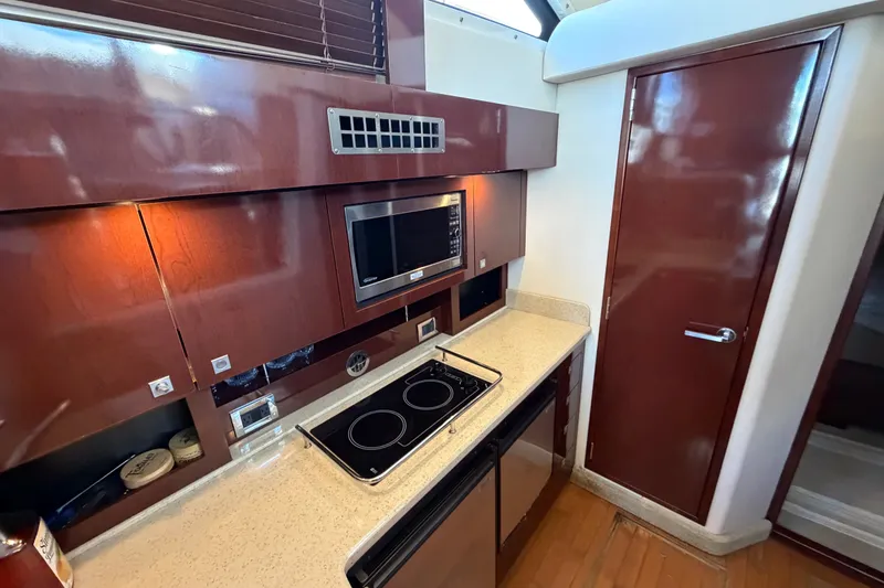 Slide: The Image of Modern kitchen interior of 2010 Sea Ray 390 Sedan Bridge yacht with microwave and stovetop. - 57