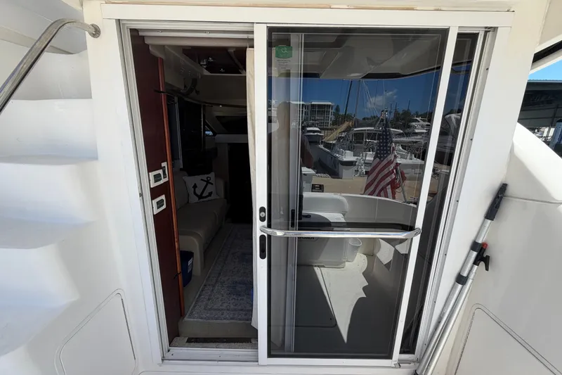 Slide: The Image of 2010 Sea Ray 390 Sedan Bridge yacht interior with sliding glass door and marina view. - 49