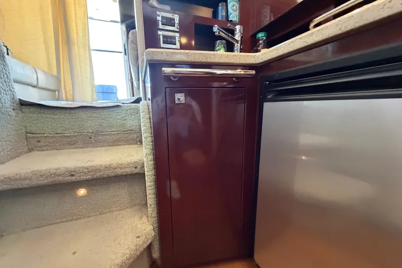 Slide: The Image of Interior of 2010 Sea Ray 390 Sedan Bridge, featuring kitchen area with stairs and cabinetry. - 80