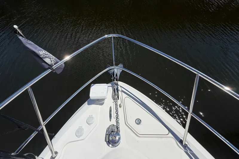 Slide: The Image of Bow view of 2010 Sea Ray 390 Sedan Bridge, featuring sleek railings and calm water. - 7