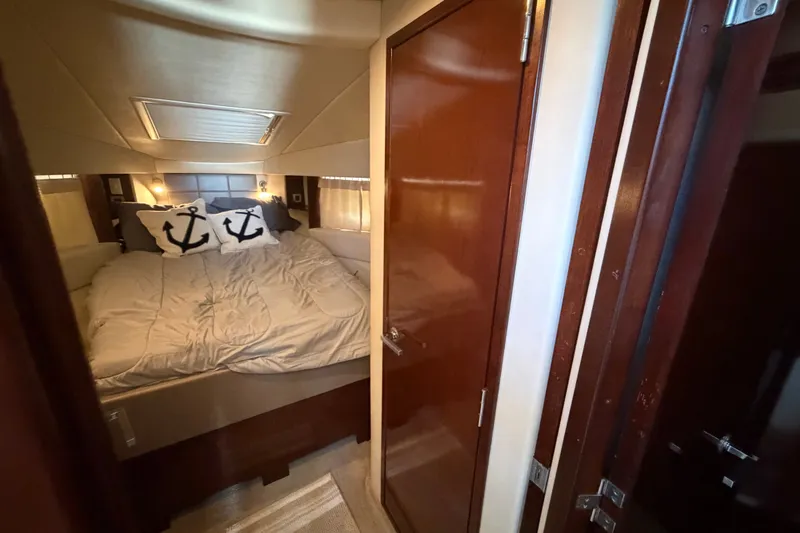 Slide: The Image of Cozy bedroom interior of 2010 Sea Ray 390 Sedan Bridge with nautical-themed pillows. - 98
