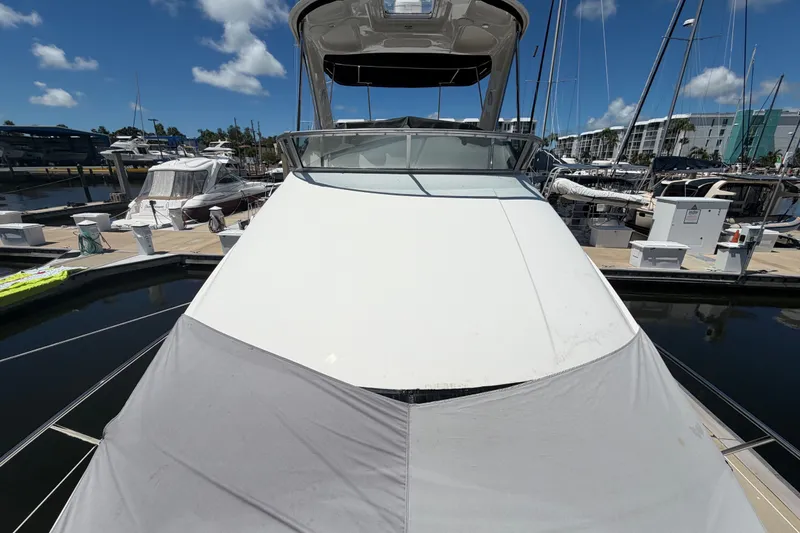Slide: The Image of 2010 Sea Ray 390 Sedan Bridge yacht docked at marina under clear blue sky. - 9