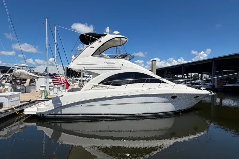 Slide: The Image of 2010 Sea Ray 390 Sedan Bridge yacht docked at marina under clear blue sky. - 4