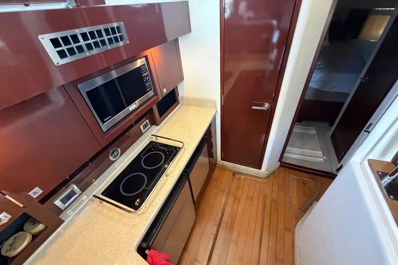 Slide: The Image of Modern kitchen interior of 2010 Sea Ray 390 Sedan Bridge yacht with stove and microwave. - 56