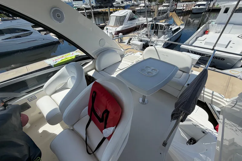 Slide: The Image of 2010 Sea Ray 390 Sedan Bridge yacht interior with white seating and table at marina. - 32