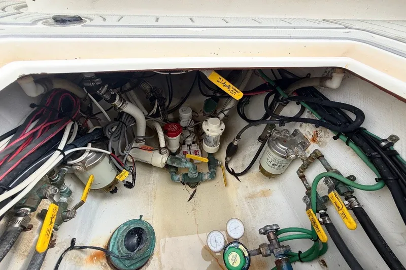 Slide: The Image of Engine compartment of a 2006 Contender 27 Open boat, showing hoses and valves. - 9