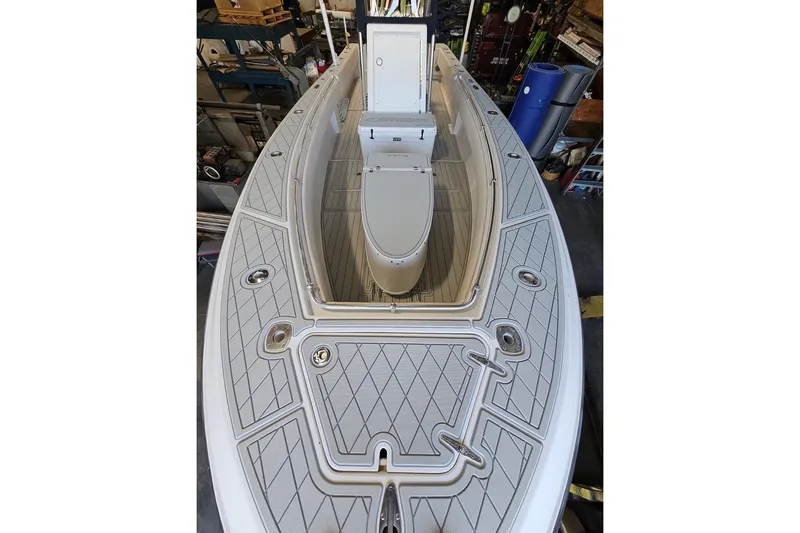 Slide: The Image of 2006 Contender 27 Open boat deck with storage compartments in a workshop setting. - 13