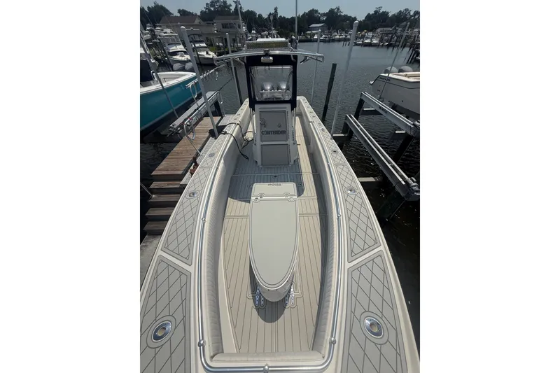 Slide: The Image of 2006 Contender 27 Open boat docked at marina, showcasing spacious deck and sleek design. - 3
