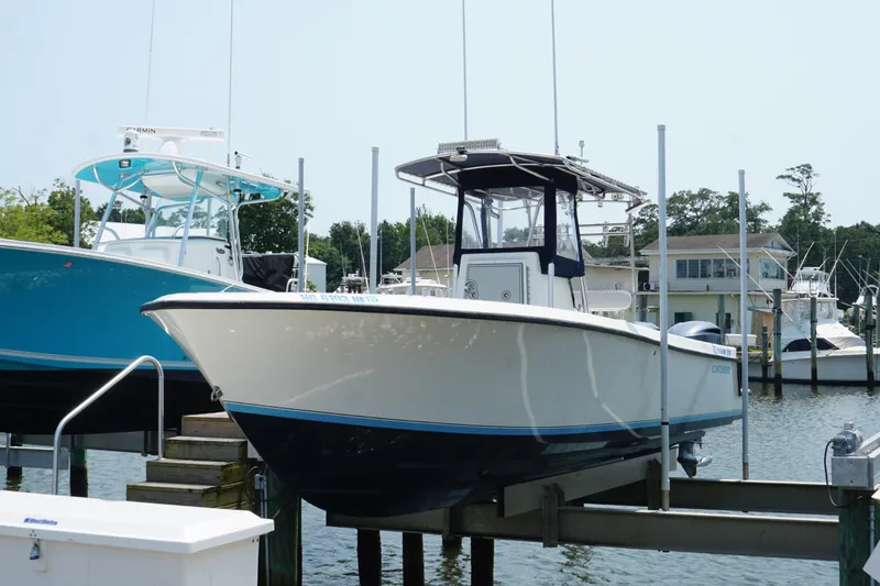 Slide: The Image of 2006 Contender 27 Open boat docked at a marina, surrounded by other vessels. - 16