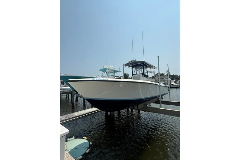 Slide: The Image of 2006 Contender 27 Open boat docked on a lift in a marina. - 8