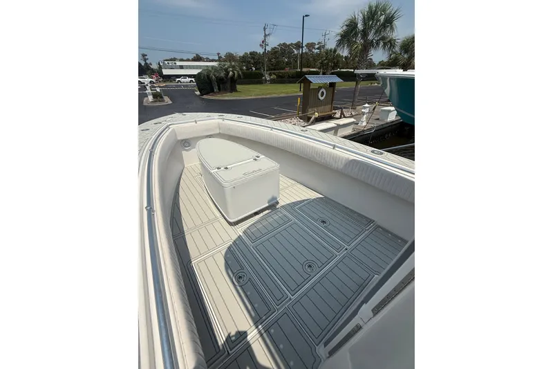 Slide: The Image of 2006 Contender 27 Open boat deck with storage compartment, docked near palm trees. - 2