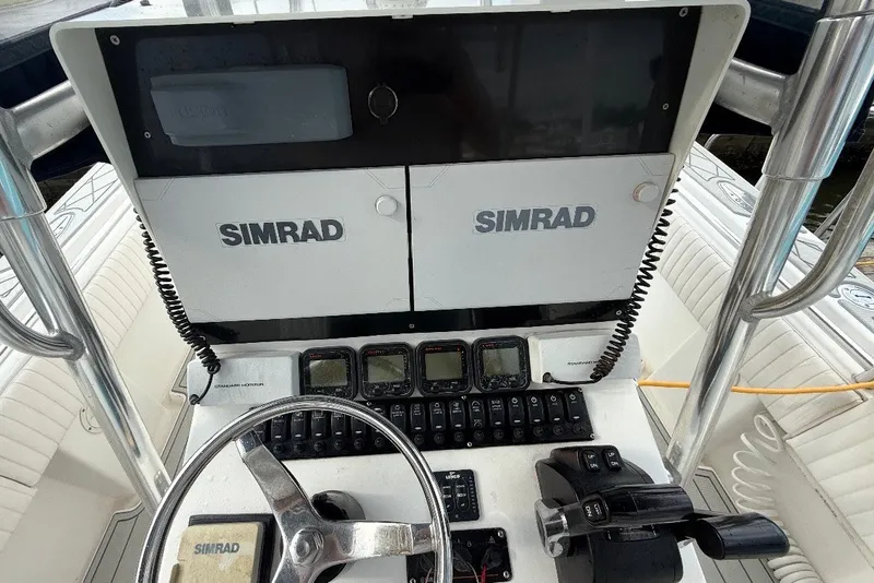 Slide: The Image of 2006 Contender 27 Open boat dashboard with Simrad navigation equipment and controls. - 11