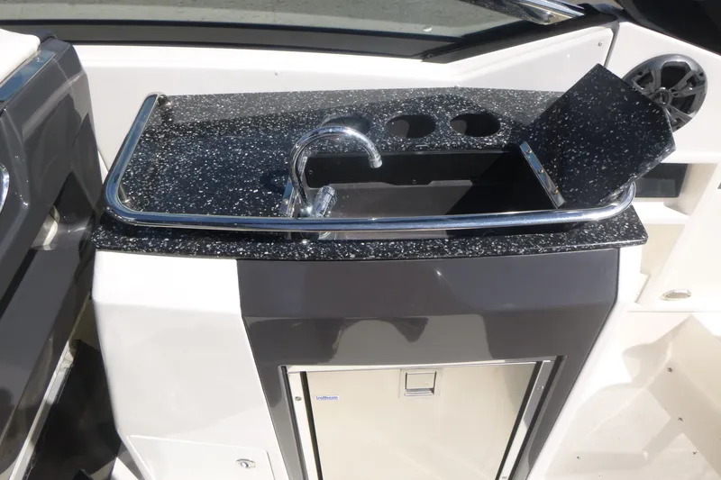 Slide: The Image of 2014 Monterey 288SS Super Sport boat kitchenette with sink and storage. - 17