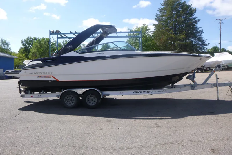 The Image of 2014 Monterey 288SS Super Sport boat on trailer, parked outdoors under clear sky. - 1