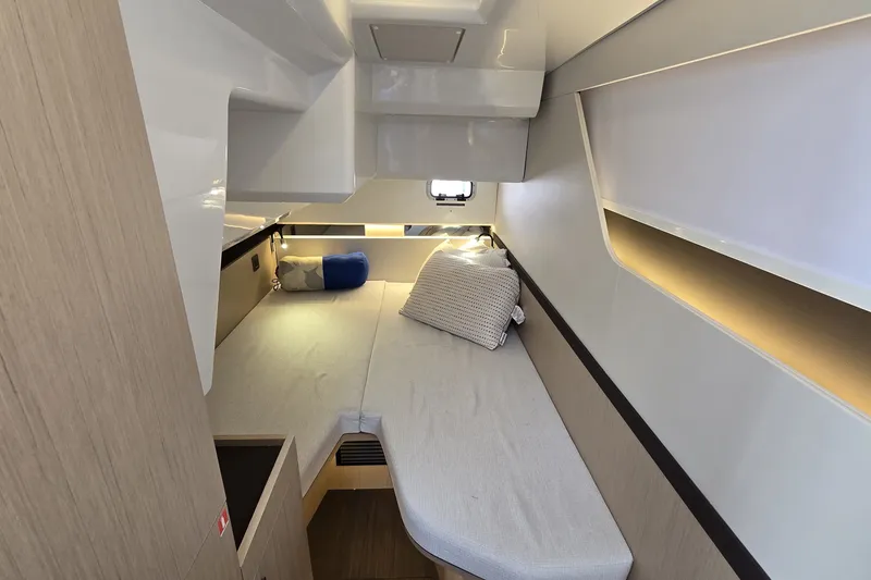 Slide: The Image of 2025 Four Winns TH36 cabin interior with modern design and cozy bedding. - 22