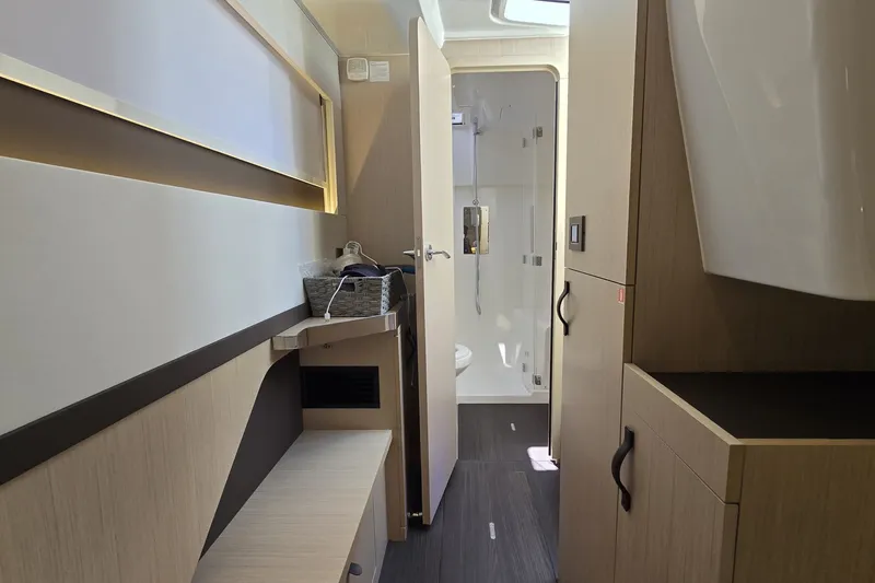 Slide: The Image of Interior of 2025 Four Winns TH36 yacht, featuring modern bathroom and sleek wooden cabinetry. - 18