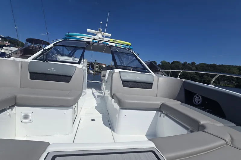 Slide: The Image of 2025 Four Winns TH36 boat with spacious seating and sleek design on a sunny day. - 16