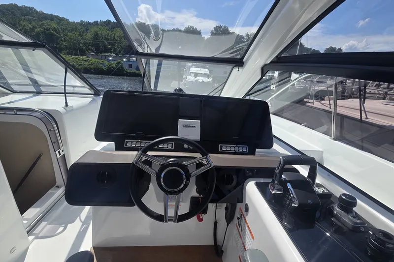 Slide: The Image of 2025 Four Winns TH36 boat cockpit with steering wheel and control panel. - 13