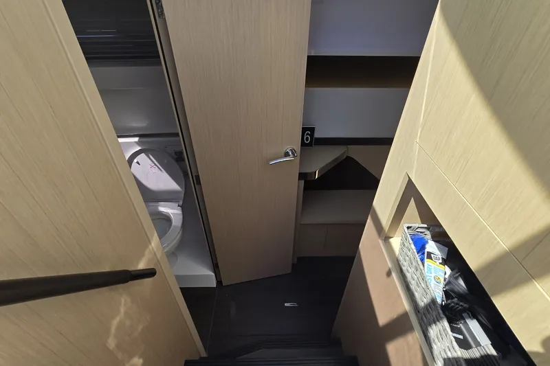 Slide: The Image of Interior view of 2025 Four Winns TH36 yacht, featuring a compact bathroom and storage area. - 20