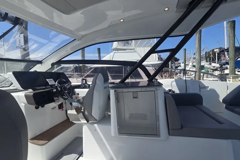 Slide: The Image of Interior view of 2025 Four Winns TH36 yacht, featuring modern helm and seating area. - 11