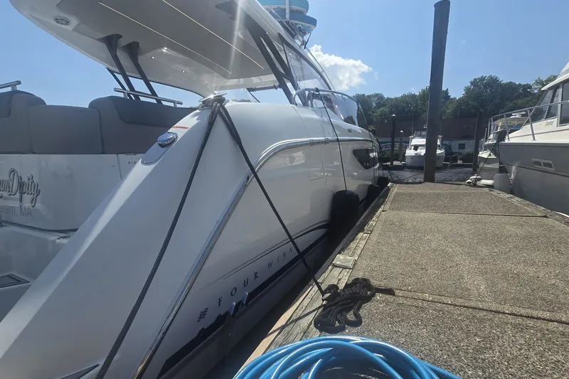 Slide: The Image of 2025 Four Winns TH36 yacht docked at marina under clear blue sky. - 1