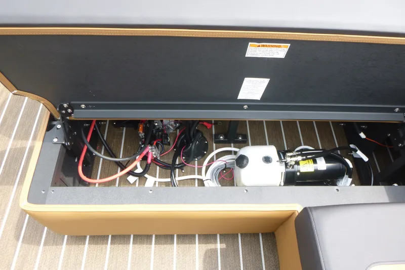 Slide: The Image of Open storage compartment of 2027 Premier 230 Sunsation RS - CL boat, showing wiring and equipment. - 17