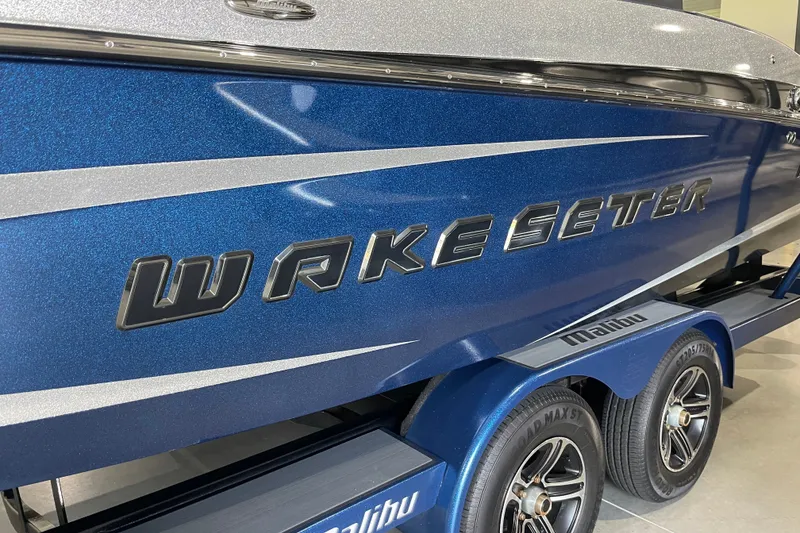 Slide: The Image of 2015 Malibu Wakesetter 24 MXZ boat, blue with silver accents, on trailer. - 5