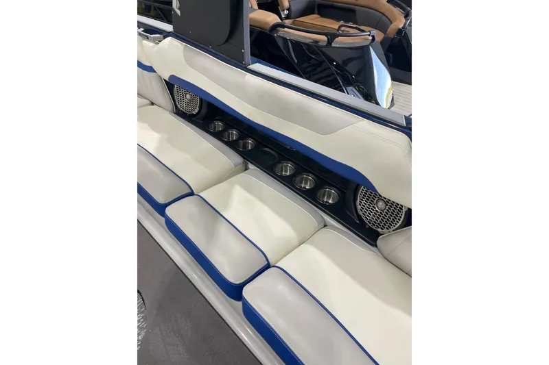 Slide: The Image of 2015 Malibu Wakesetter 24 MXZ interior with white and blue seating, cup holders, and speakers. - 19
