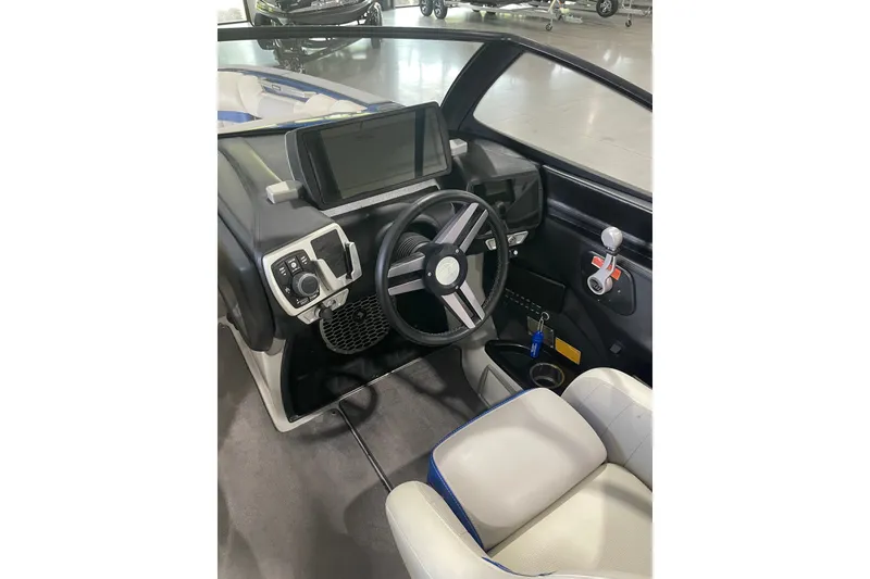 Slide: The Image of Interior of 2015 Malibu Wakesetter 24 MXZ boat, featuring steering wheel and control panel. - 16