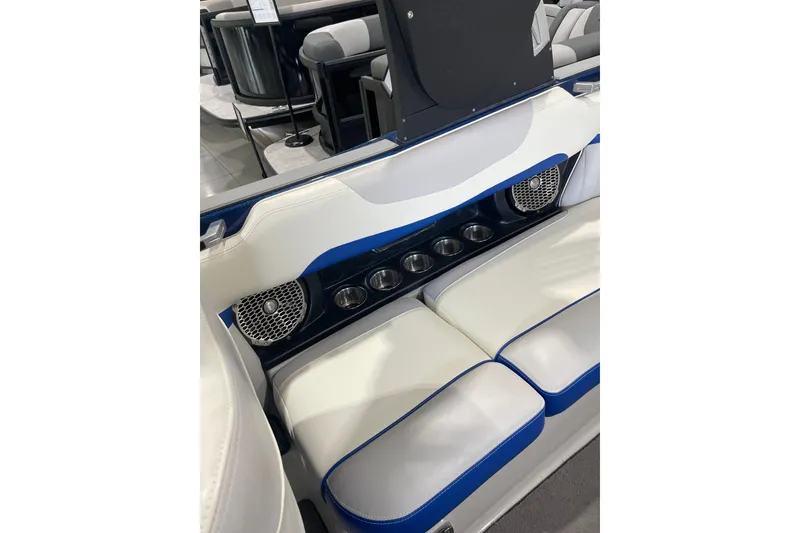 Slide: The Image of 2015 Malibu Wakesetter 24 MXZ interior with white seats, blue accents, and cup holders. - 18