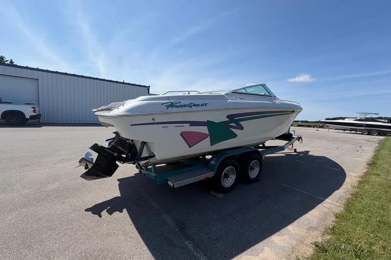 Slide: The Image of 1995 Powerquest 257 Legend boat on trailer, parked outdoors under clear blue sky. - 4