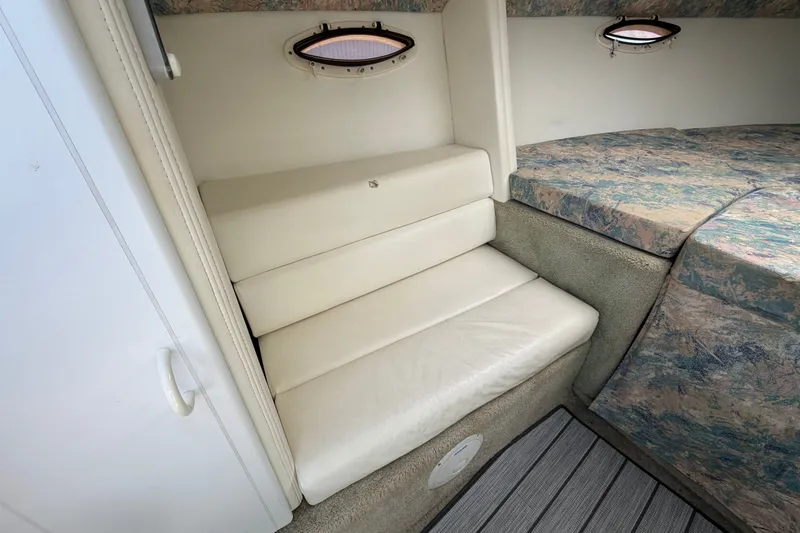 Slide: The Image of Interior cabin of 1995 Powerquest 257 Legend boat with cushioned seating and portholes. - 16