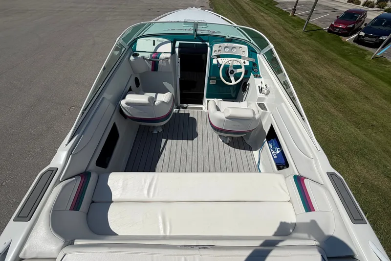 Slide: The Image of 1995 Powerquest 257 Legend boat interior with white seating and teal dashboard. - 9
