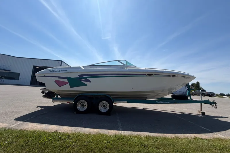 Slide: The Image of 1995 Powerquest 257 Legend boat on trailer, parked outdoors under clear sky. - 5