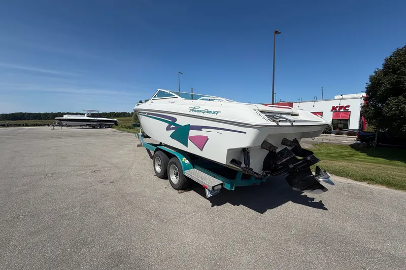 Slide: The Image of 1995 Powerquest 257 Legend boat on trailer in parking lot, clear sky background. - 2