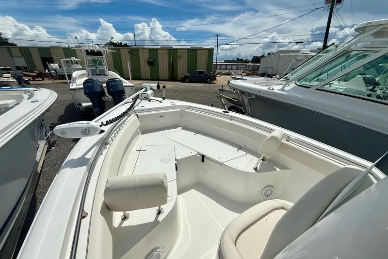 Slide: The Image of 2023 Sea Hunt Ultra 239SE boat docked, showcasing spacious seating and modern design. - 11