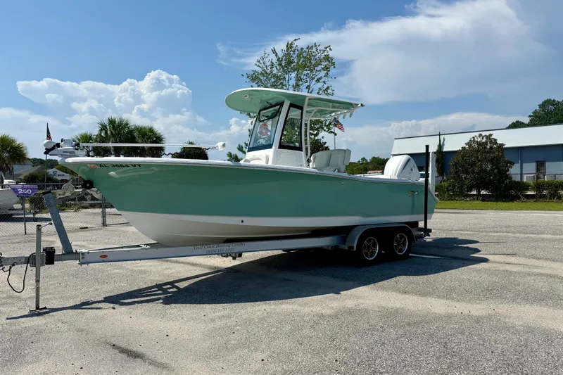 Slide: The Image of 2023 Sea Hunt Ultra 239SE boat on trailer, parked outdoors under a clear sky. - 1