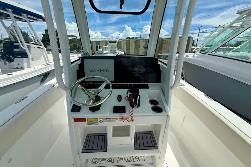 Slide: The Image of 2023 Sea Hunt Ultra 239SE boat console with Garmin navigation system and steering wheel. - 10