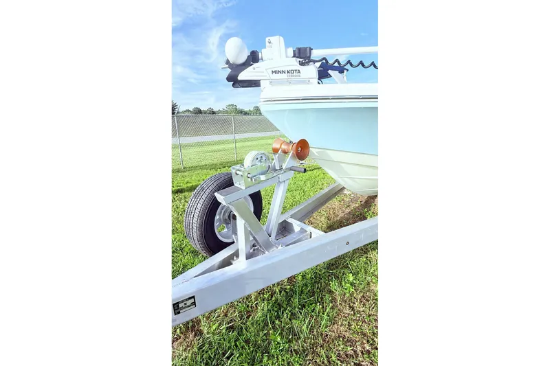 Slide: The Image of 2023 Pathfinder 2500 Hybrid boat on trailer with Minn Kota motor, grassy background. - 26