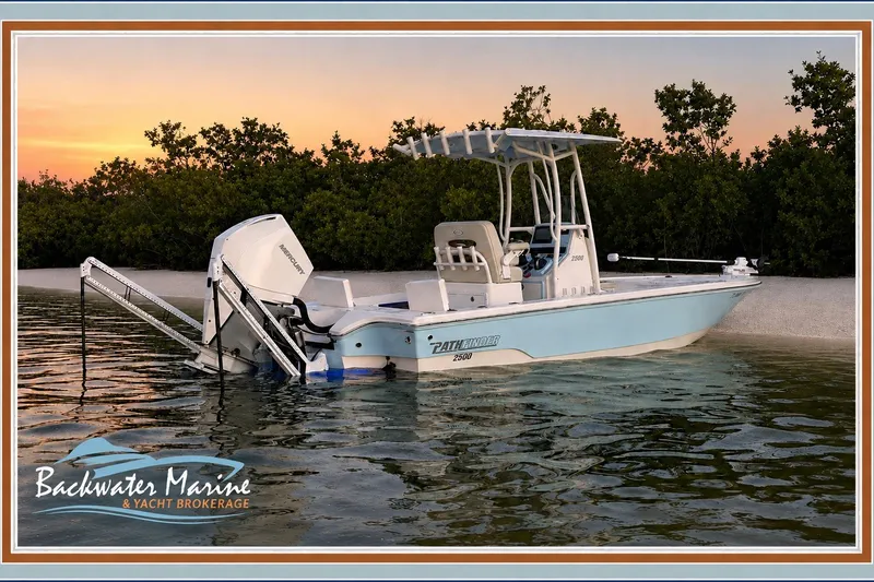 Slide: The Image of 2023 Pathfinder 2500 Hybrid boat on calm water at sunset, near a sandy shore. - 2