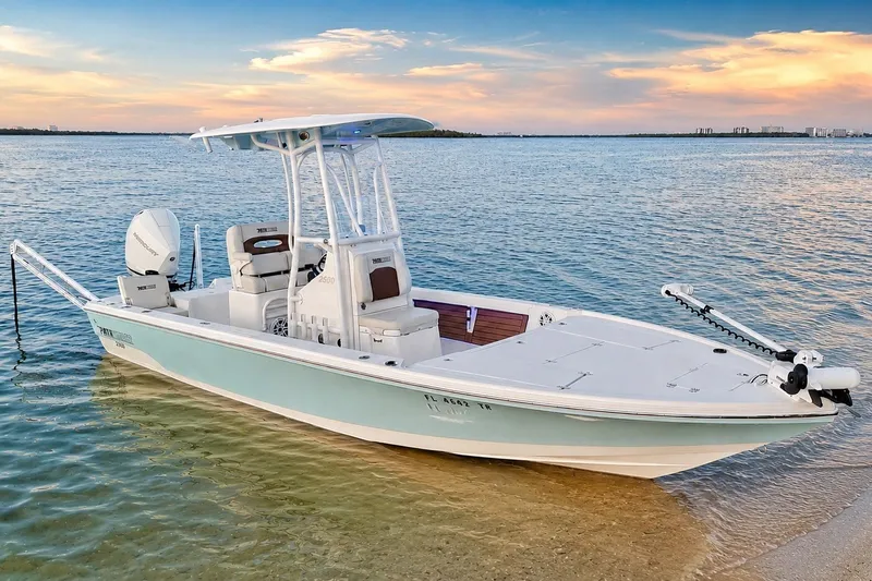Slide: The Image of 2023 Pathfinder 2500 Hybrid boat anchored on a serene beach at sunset. - 7
