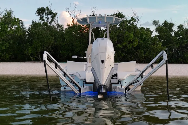 Slide: The Image of 2023 Pathfinder 2500 Hybrid boat anchored in shallow water near a sandy beach. - 12