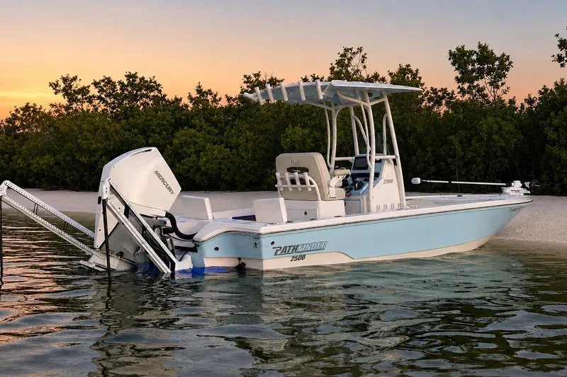 The Image of 2023 Pathfinder 2500 Hybrid boat in serene water at sunset, near lush greenery. - 0