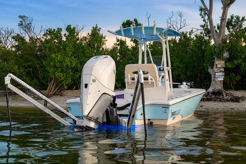 Slide: The Image of 2023 Pathfinder 2500 Hybrid boat docked near a scenic shoreline with lush greenery. - 13