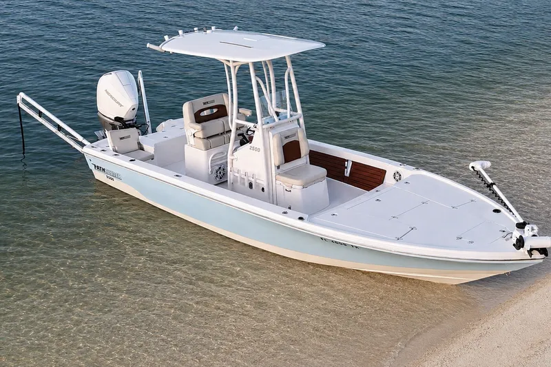 Slide: The Image of 2023 Pathfinder 2500 Hybrid boat docked on clear water near sandy shore. - 9