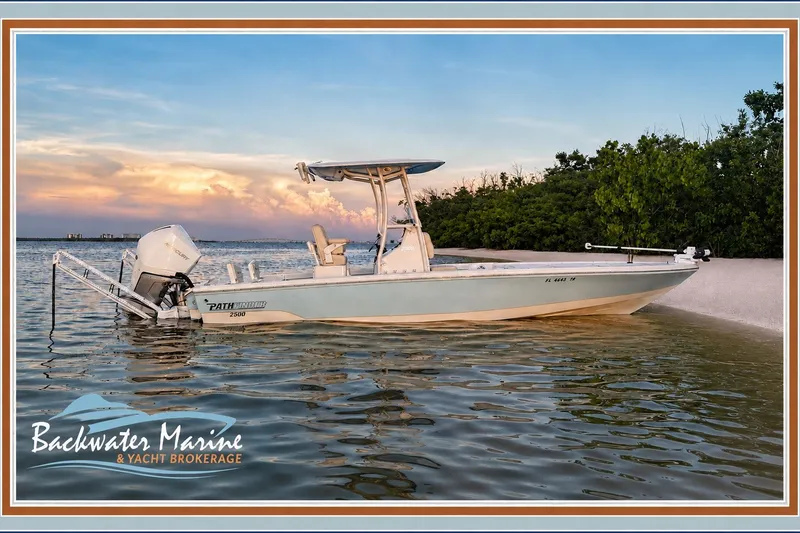 Slide: The Image of 2023 Pathfinder 2500 Hybrid boat docked by the shore at sunset. - 5