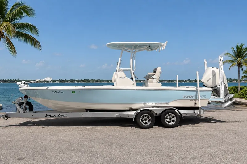 Slide: The Image of 2023 Pathfinder 2500 Hybrid boat on trailer by waterfront, palm trees in background. - 23